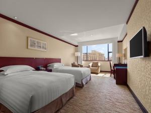 Postel nebo postele na pokoji v ubytování Beijing Poly Plaza Hotel