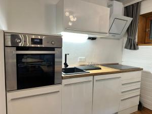 a kitchen with white cabinets and a stove top oven at Appartement Tegelberg in Steingaden