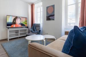 a living room with a couch and a tv at Travel Homes - Niffel 2 - Un havre de paix près du Parc in Mulhouse