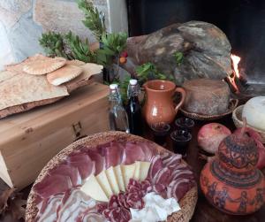 een tafel met een bord kaas en andere voedingsmiddelen bij Agriturismo Su Cuile Countryside Comfort Rooms in Budoni