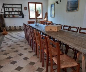 uma grande mesa de madeira com cadeiras e uma caixa sobre ela em Agriturismo Su Cuile Countryside Comfort Rooms em Budoni