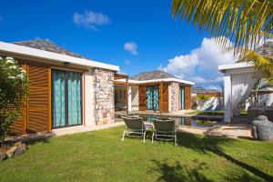 a house with two chairs in the yard at Marosalie in Pereybere