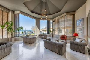 a living room with couches and chairs and large windows at Hotel Nafpaktos in Nafpaktos