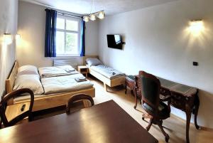 卡爾斯坦的住宿－Bunkr Karlštejn，客房设有桌子、床和书桌。