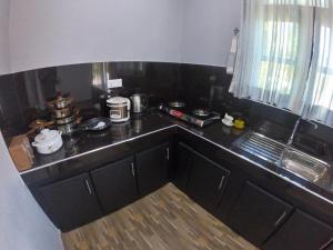 a kitchen with a black counter top with a counter top at Juliya Guest House in Negombo
