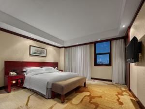 Postel nebo postele na pokoji v ubytování Beijing Poly Plaza Hotel