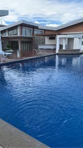 uma grande piscina azul em frente a uma casa em Camilyn Home Stay em General Trias
