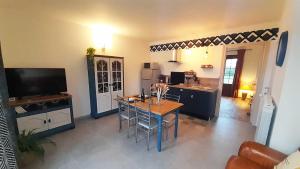 a living room with a table and a kitchen at Villa Saint Roch in Boult-sur-Suippe