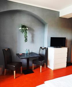 - une salle à manger avec une table, des chaises et une télévision dans l'établissement Hotel Altes Salzamt, à Bad Dürrenberg