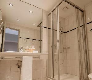 a bathroom with a shower and a sink at Hotel Schloss Hünigen in Konolfingen