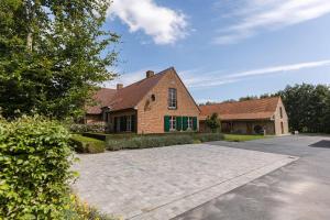 une maison en briques avec une allée en face de celle-ci dans l'établissement Quiet and authentic vacation property with pond, à Harelbeke