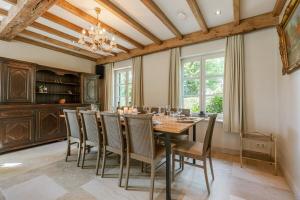 una sala da pranzo con tavolo e sedie in legno di Quiet and authentic vacation property with pond a Harelbeke