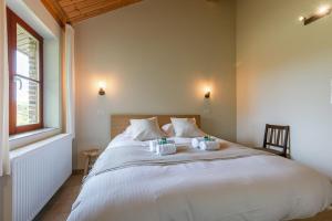 um quarto com uma grande cama branca e 2 toalhas em Quiet and authentic vacation property with pond em Harelbeke