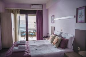 ein Schlafzimmer mit einem großen Bett und einem Balkon in der Unterkunft Drenia Studios in Amolianí