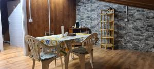 a dining room table with chairs and a stone wall at La collina in Tagliacozzo