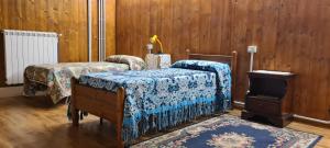een slaapkamer met 2 bedden, een open haard en houten wanden bij La collina in Tagliacozzo