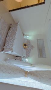 białe łóżko z 2 poduszkami i lustrem w obiekcie Park hills gillco w mieście Mohali