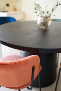 une table noire avec une chaise rose devant elle dans l'établissement Casa del Vince, à Canicattì