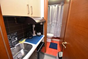 a small kitchen with a sink and a toilet at Central Apartment Thessaloniki-Easy Parking in Thessaloniki
