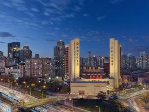 Beijing Poly Plaza Hotel في بكين: أفق المدينة مع المباني الطويلة والطريق السريع