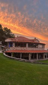 a building with a red roof with a green lawn at Ktima Faki in Litochoro