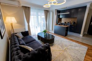 a living room with a blue couch and a kitchen at Olive Apartment in Timişoara