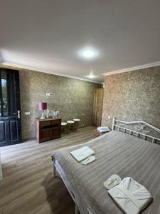 1 dormitorio con 1 cama con 2 toallas en Odamarani en Kutaisi