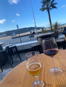 twee glazen wijn op een tafel met uitzicht op het strand bij Maison Basque mitoyenne tout confort in Hendaye