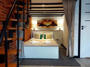 a bedroom with a bed in a brick wall at MORSKI SEN-Przytulne studio z antresolą w centrum Mielna in Mielno +7 photos