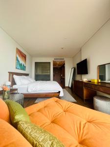 een hotelkamer met een bed en een televisie bij Apec Mandala Mũi Né in Ấp Long Sơn