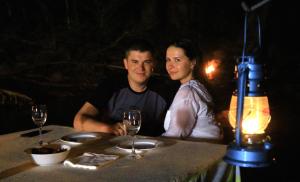 un hombre y una mujer sentados en una mesa con copas de vino en Leopard Glamping - Luxury Mobile Campsite in Yala & Kumana, en Matara