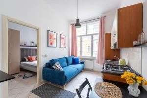 a living room with a blue couch in a kitchen at Tyrsova Apartment in Prague