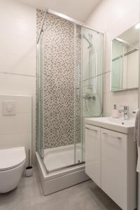 a bathroom with a shower and a toilet and a sink at Villa Stonehouse 2 in Milna +30 photos