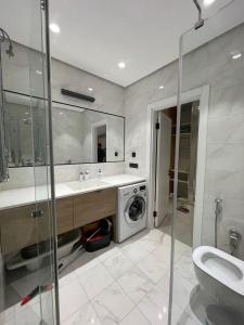 uma casa de banho com um lavatório e uma máquina de lavar roupa em Sea Breeze Lighthouse 1 em Baku