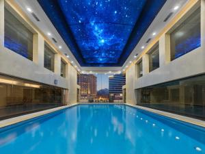 a swimming pool in a building with a star ceiling at Beijing Poly Plaza Hotel in Beijing