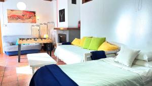 Sala de estar con 2 camas y mesa en CASA LOS ABETOS cerca de la Alhambra y Sierra Nevada, en Cenes de la Vega