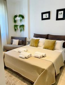 una camera da letto con un grande letto con asciugamani di VIATOREM Suites a Torre dell'Orso
