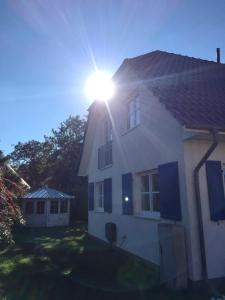 een wit huis met de zon erop bij Haus Zeesenboot Luv in Hiddensee