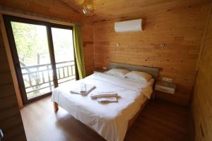 a bedroom with a bed in a wooden cabin at Cirali Villas 2 in Cıralı