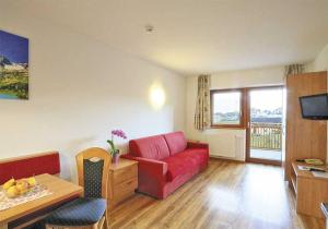a living room with a red couch and a table at Apartment Pichlerhof in San Lorenzo di Sebato