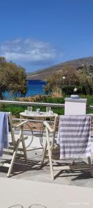 a picnic table and chairs with a view of the water at White Lotus seaside studio in Kinion