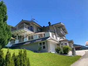 Una gran casa blanca con balcones en una colina en Apartment Kerer en Wald im Pinzgau