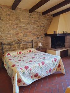 een bed in een kamer met een bakstenen muur bij Casa Amedeo in Chianni