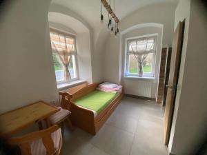 Cette petite chambre comprend un lit et deux fenêtres. dans l'établissement Chata Sedmikráska, à Malá Morávka