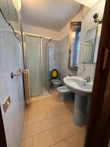 a bathroom with a toilet and a sink and a shower at Appartamento Mino in Magenta