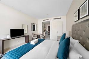 a bedroom with a large bed with blue pillows at Luxurious Studio with Stunning Views at Damac Celestia in Dubai
