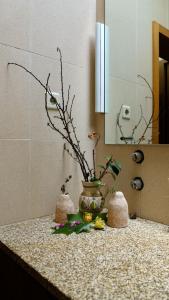 a vase with flowers on a counter in a bathroom at Jardim da Guida in Abragão