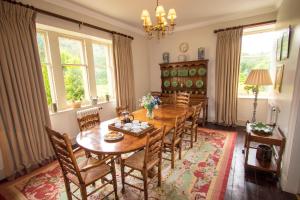 a dining room with a wooden table and chairs at Inveroykel Lodge at Rosehall in Rosehall