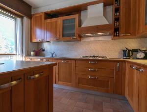a kitchen with wooden cabinets and a stove top oven at La Soliva Big House in Primaluna