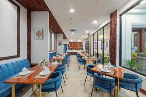 um restaurante com mesas de madeira e cadeiras azuis em Homewood Hotel By Seuya Hotel em Siem Reap